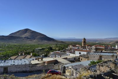 High angle view of village against blue sky