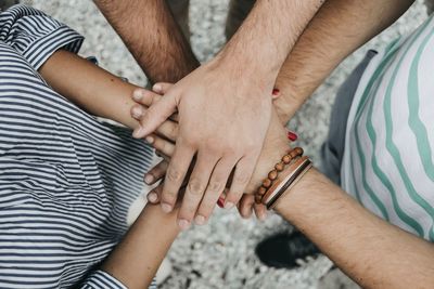 Cropped image of friends stacking hands