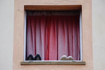 Shoes on window sill against curtain