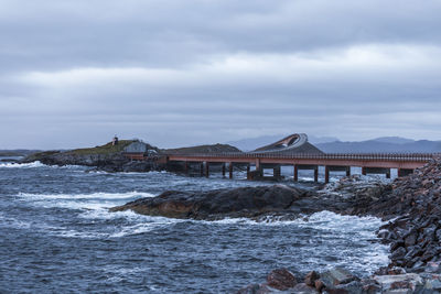 Houses by sea against sky