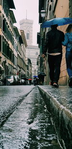 Wet street amidst buildings in city during rainy season