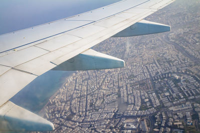 Close-up of aircraft wing against cloudy sky