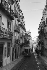 Cars on street in city against clear sky