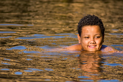Portrait of smiling girl swimming in water
