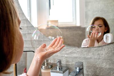 Relaxed young girl model poses in cozy bathroom