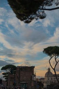 Buildings in town against sky during sunset
