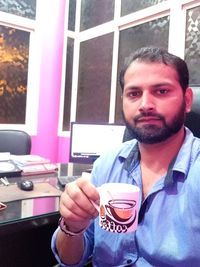 Portrait of young man drinking coffee