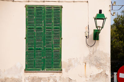 Closed green window on wall of building