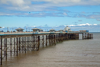 Pier over sea and buildings against sky