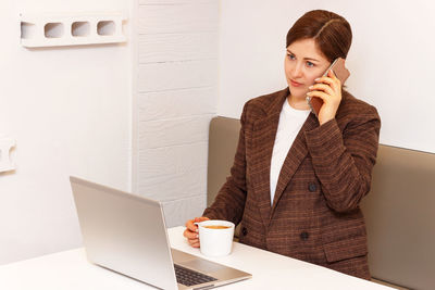 Young woman using mobile phone on table