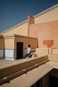 Rear view of woman walking at historic building 