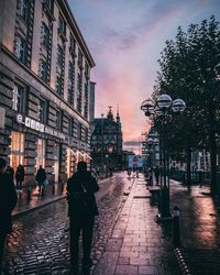 People walking on street amidst buildings in city
