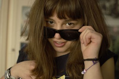 Close-up portrait of smiling young woman wearing sunglasses