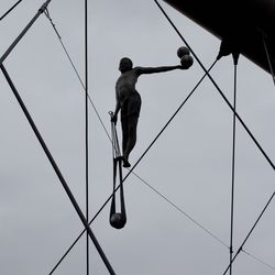 Low angle view of man working against clear sky
