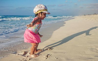 Full length of girl at beach against sky