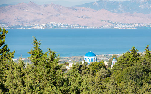 Zia and a blue white village church in front of the turkish mainland in the north on the island kos