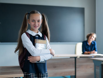 Portrait of young woman standing in office