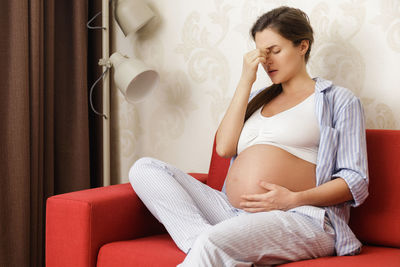 Young woman sitting on sofa at home