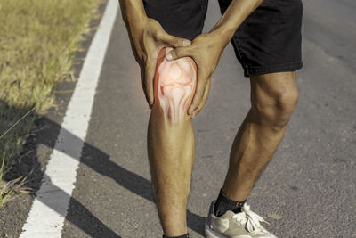 Low section of man holding hands on street