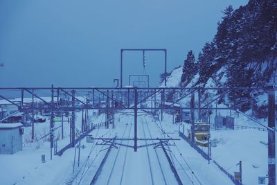 Train on snow covered railroad tracks against sky