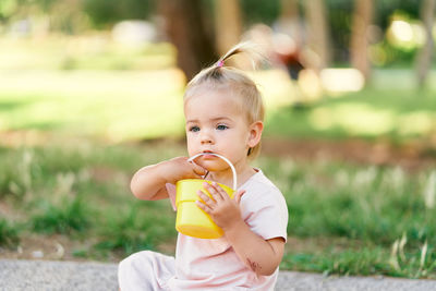 Portrait of cute boy holding ice cream outdoors