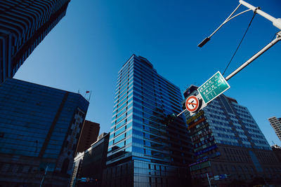 Low angle view of modern buildings against blue sky