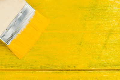 Close-up of paintbrush on yellow table