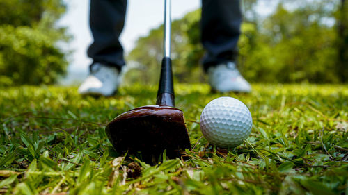 Low section of man playing golf ball on grass