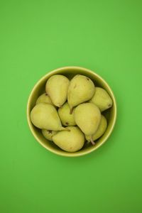 High angle view of fruits in bowl against green background