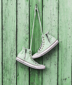 Close-up of shoes hanging on wooden wall