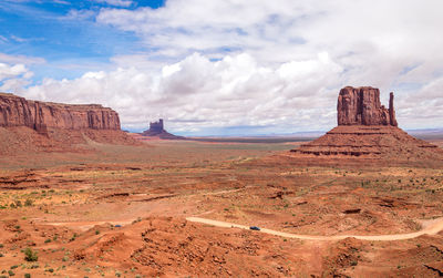 Rock formations on landscape against cloudy sky