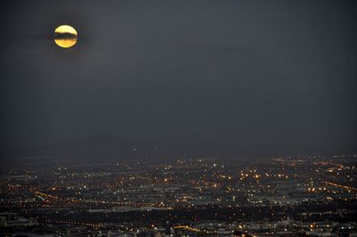Illuminated cityscape against sky at night