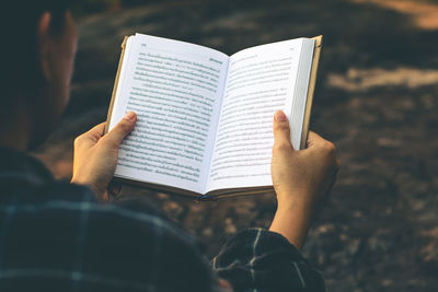 Midsection of woman reading book