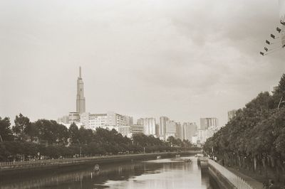 View of river and buildings against sky