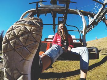 Young woman on ski lift on sunny day