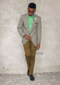 Portrait of young man standing against wall