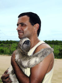 Man with sloth against sky