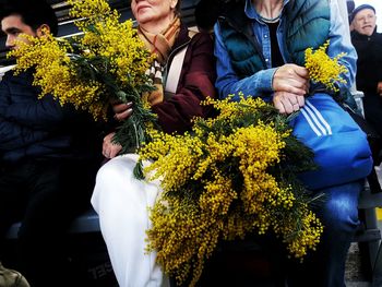 Rear view of people holding flower bouquet