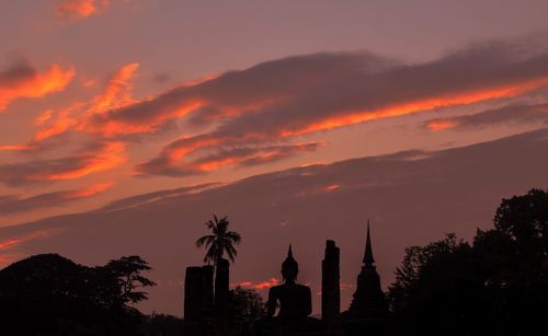 Silhouette trees and buildings against sky during sunset