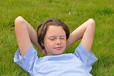 Young woman sleeping on grassy field