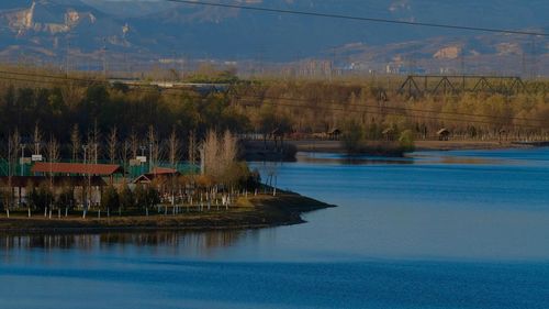 Scenic view of lake by trees against sky