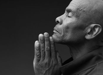 Black man praying to god on gray background with people stock image stock photo