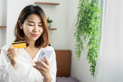 Happy asian woman enjoy shopping online by credit card and smart phone