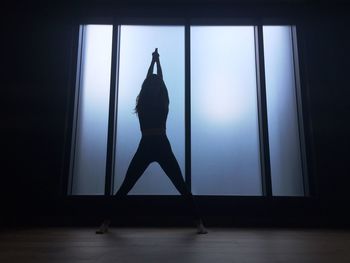 Silhouetted woman in yoga pose