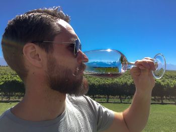 Portrait of young man wearing sunglasses against sky