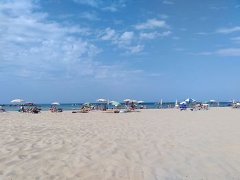 Group of people on beach against sky