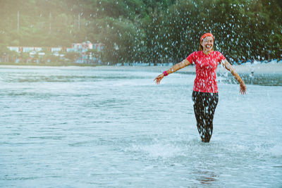 Full length of smiling boy in water