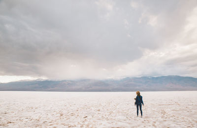 Full length of man standing on sand against sky