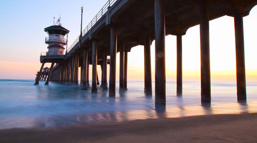 Pier on sea at sunset