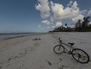 Bicycle on beach against sky